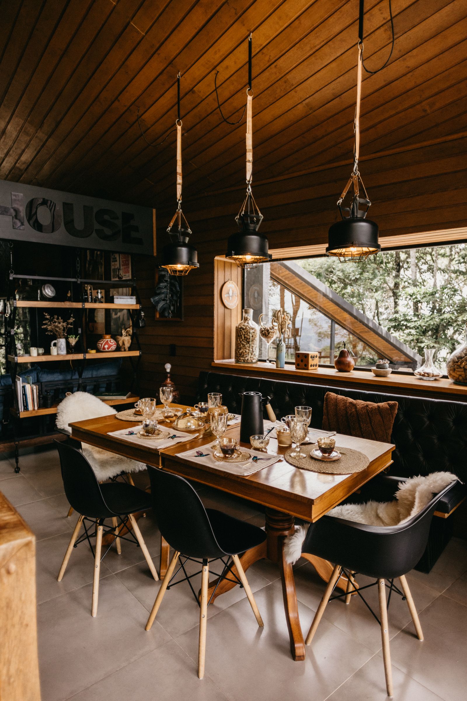 Comedor de madera con iluminación cálida y mesa preparada